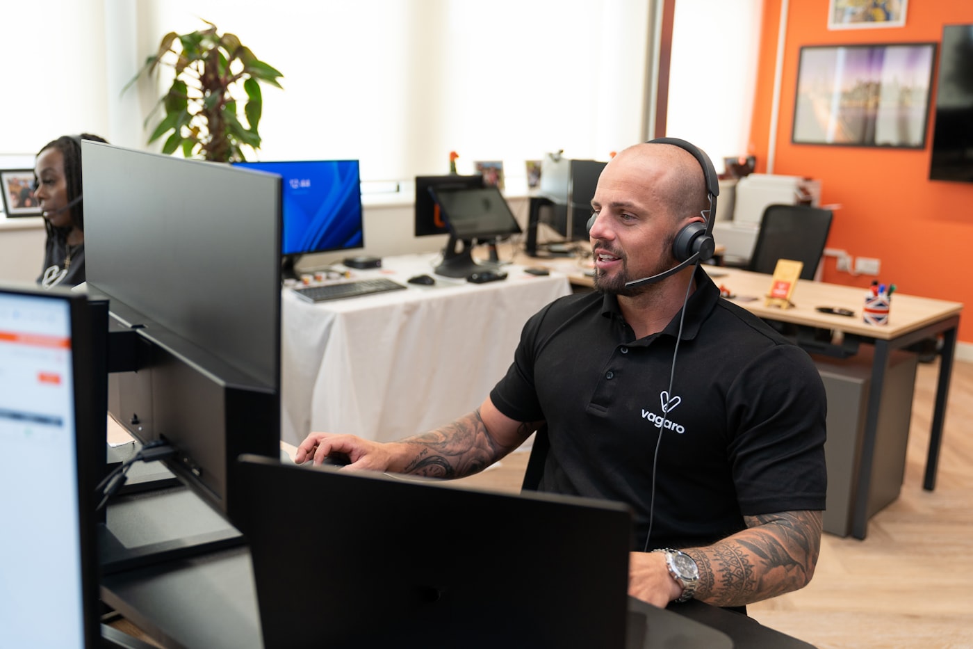 Operator wearing a headset working at a multi-screen workstation